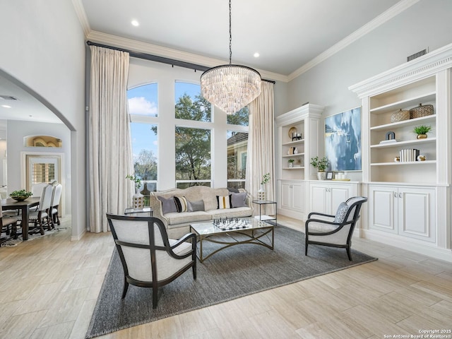 living room with a towering ceiling, ornamental molding, and light wood-type flooring