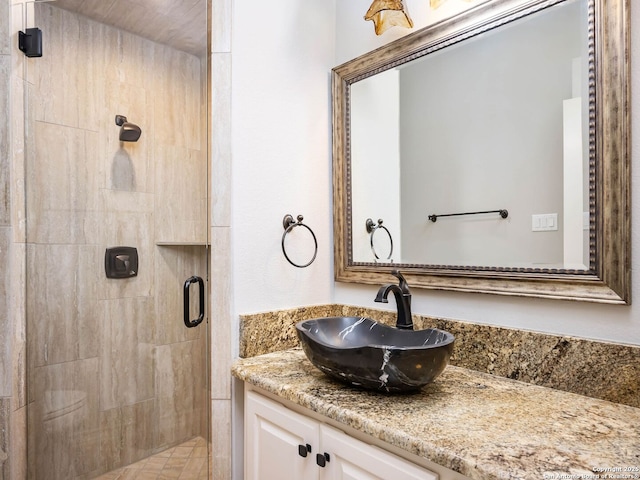 bathroom with vanity and a shower with door