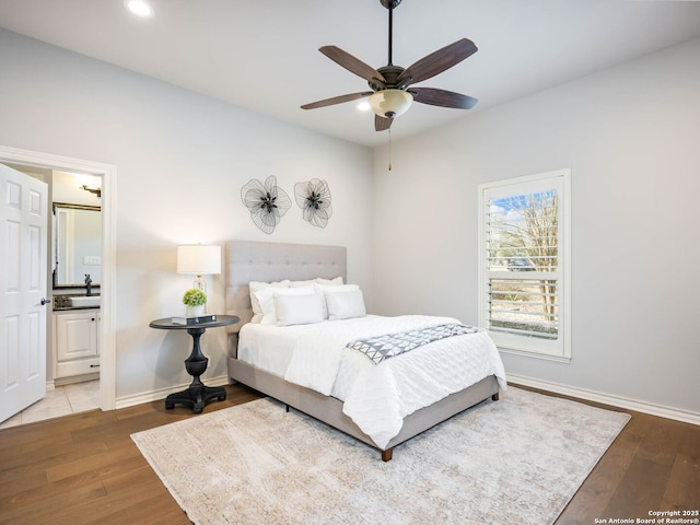 bedroom featuring hardwood / wood-style floors, ceiling fan, and ensuite bathroom