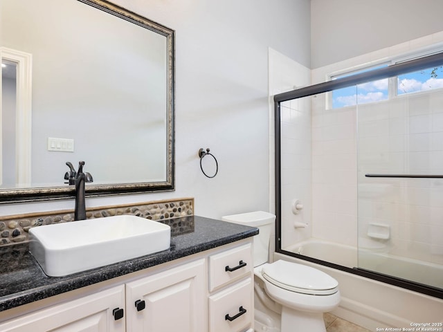 full bathroom with tile patterned flooring, vanity, combined bath / shower with glass door, and toilet