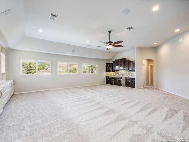 unfurnished living room featuring ceiling fan, light colored carpet, and vaulted ceiling