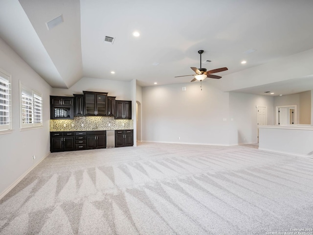 unfurnished living room with vaulted ceiling, light colored carpet, and ceiling fan