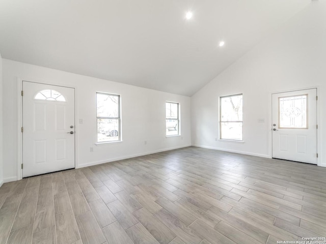 entryway featuring high vaulted ceiling and light wood-type flooring