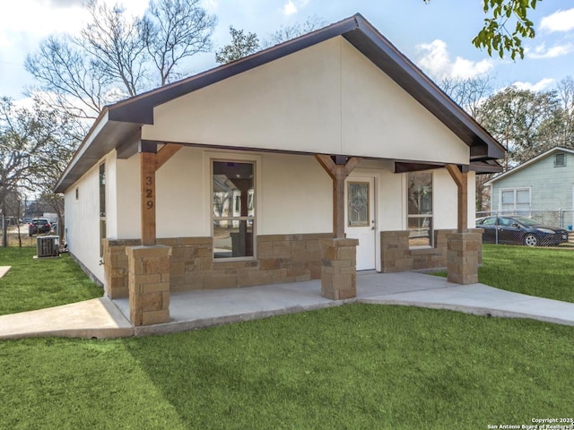 view of front of house with a front lawn and central air condition unit