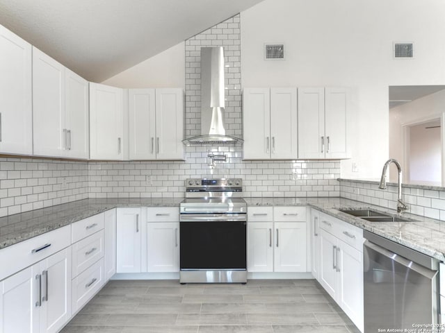 kitchen with wall chimney exhaust hood, appliances with stainless steel finishes, and white cabinets