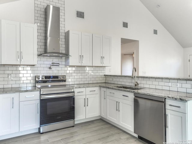 kitchen with white cabinets, sink, wall chimney exhaust hood, and appliances with stainless steel finishes