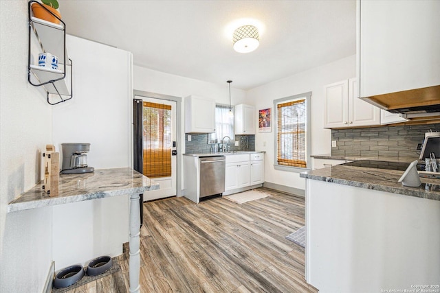 kitchen with stainless steel dishwasher, light wood-type flooring, hanging light fixtures, and white cabinets