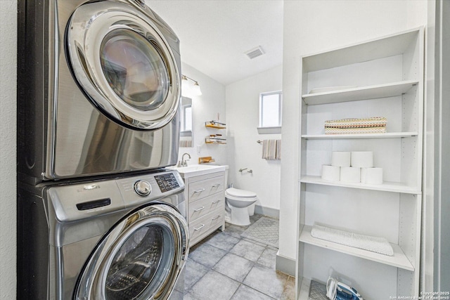 laundry area with stacked washing maching and dryer and sink