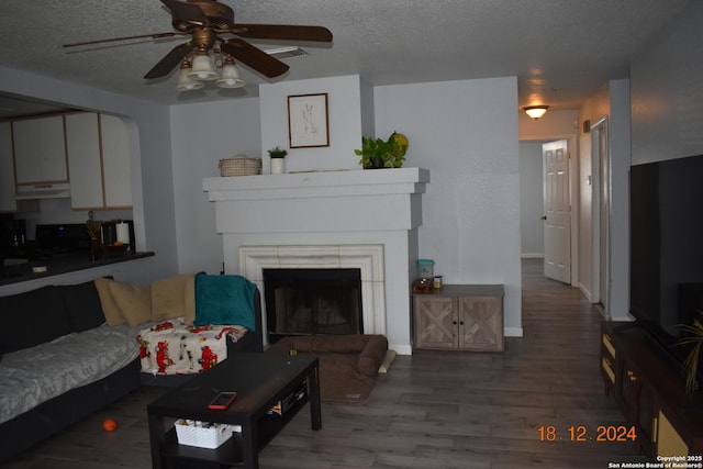 living room with hardwood / wood-style flooring, ceiling fan, and a textured ceiling