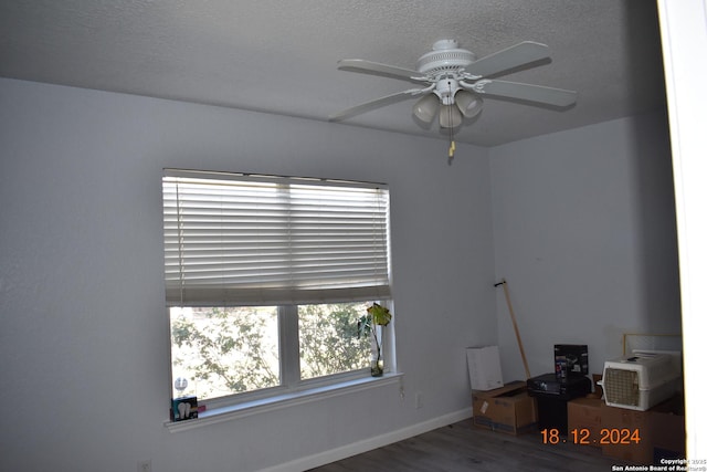 spare room featuring hardwood / wood-style flooring, ceiling fan, and a textured ceiling