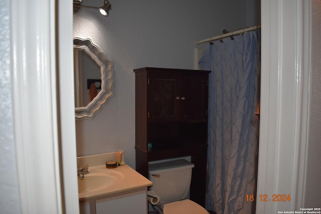 bathroom featuring walk in shower, vanity, and toilet