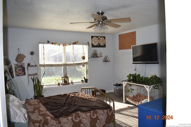 bedroom with ceiling fan and a textured ceiling