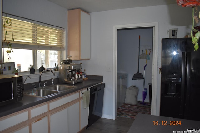 kitchen with sink, white cabinets, dark hardwood / wood-style floors, and black appliances