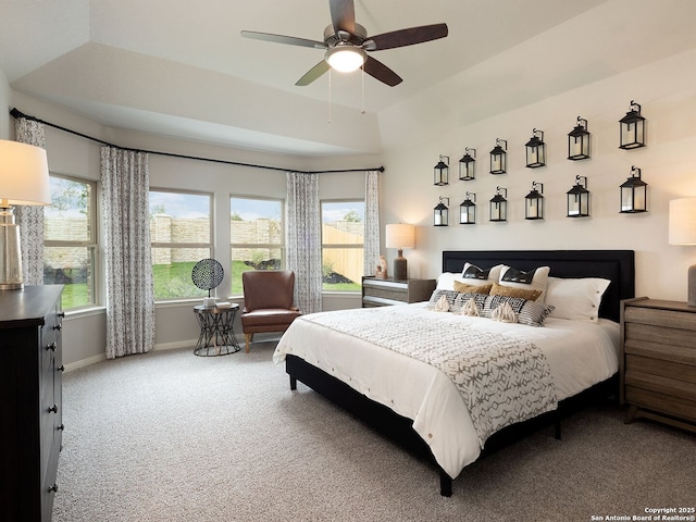 bedroom featuring ceiling fan, a raised ceiling, and carpet