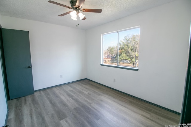 spare room featuring ceiling fan, light hardwood / wood-style floors, and a textured ceiling