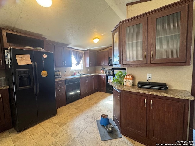 kitchen featuring lofted ceiling, dark brown cabinets, light stone counters, and black appliances