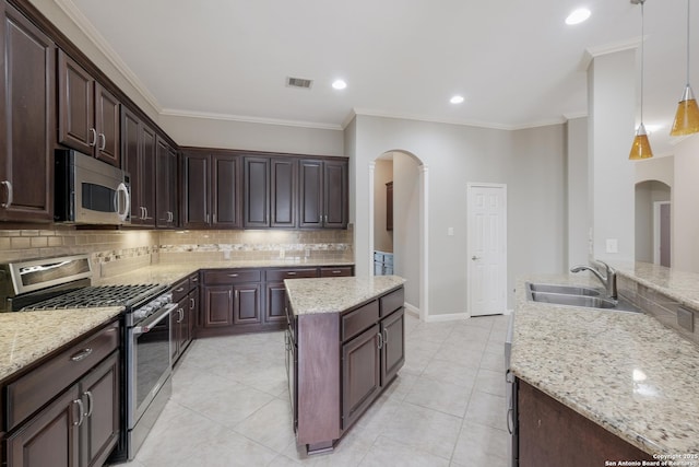 kitchen featuring appliances with stainless steel finishes, sink, pendant lighting, and dark brown cabinets