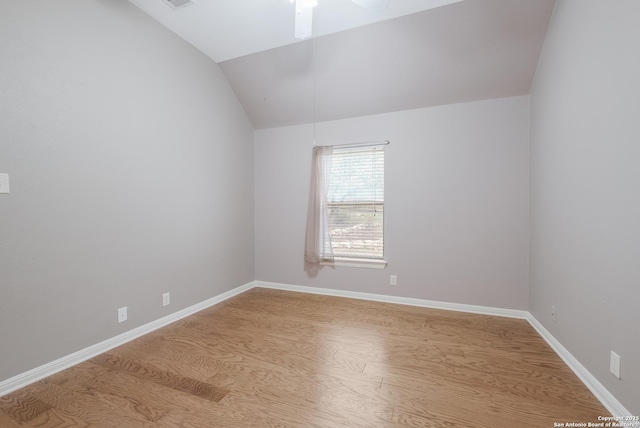 empty room with light hardwood / wood-style flooring, ceiling fan, and vaulted ceiling