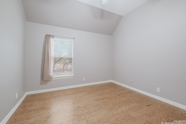 spare room with light hardwood / wood-style floors and vaulted ceiling