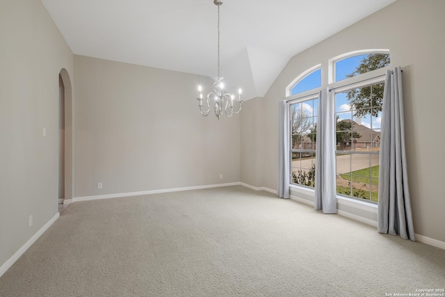 empty room featuring lofted ceiling, light colored carpet, and an inviting chandelier