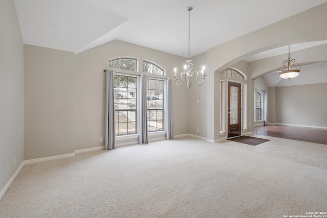 unfurnished room with lofted ceiling, a chandelier, and carpet