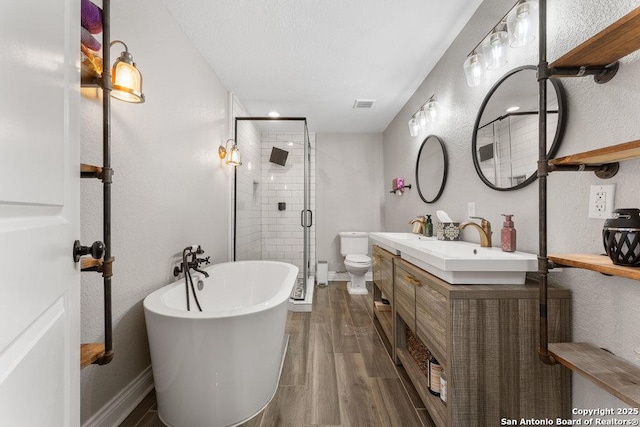 full bathroom featuring hardwood / wood-style flooring, vanity, separate shower and tub, toilet, and a textured ceiling