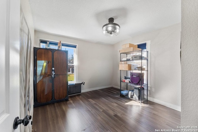 misc room featuring a textured ceiling and dark hardwood / wood-style flooring