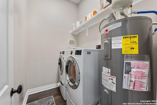 washroom featuring washing machine and dryer, electric water heater, and dark wood-type flooring