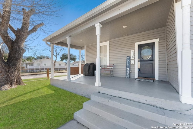 entrance to property with a yard and a porch