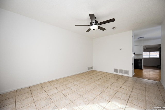 empty room featuring a ceiling fan, visible vents, and baseboards