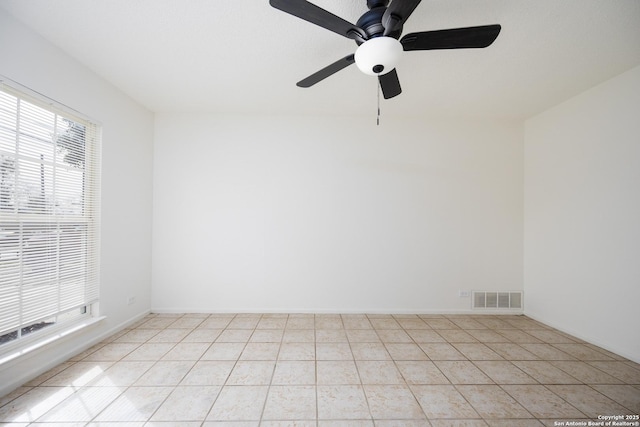 unfurnished room with a ceiling fan, light tile patterned flooring, baseboards, and visible vents