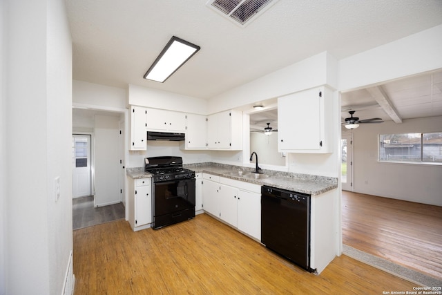 kitchen featuring visible vents, light wood-type flooring, black appliances, under cabinet range hood, and a sink