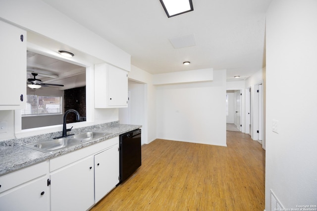 kitchen with dishwasher, light countertops, white cabinets, and a sink