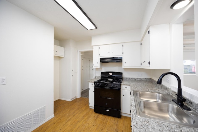 kitchen with visible vents, under cabinet range hood, light wood-type flooring, black range with gas cooktop, and a sink