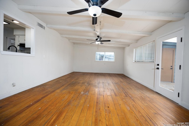 unfurnished room with visible vents, beam ceiling, baseboards, and wood-type flooring