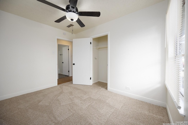 unfurnished bedroom with visible vents, baseboards, light carpet, a closet, and a ceiling fan