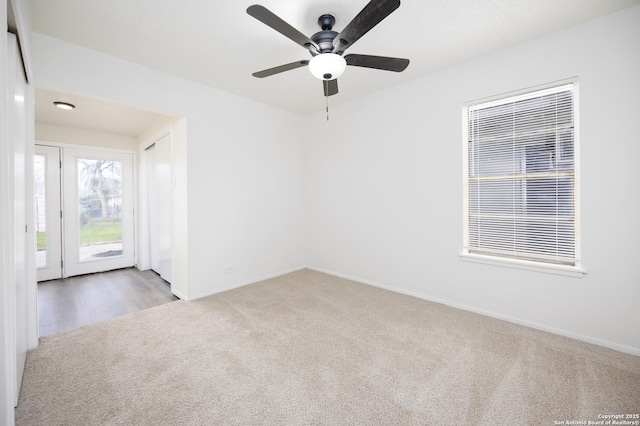 unfurnished room featuring a ceiling fan, baseboards, and carpet floors