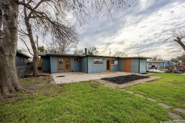 rear view of house featuring a patio area, fence, french doors, and a lawn