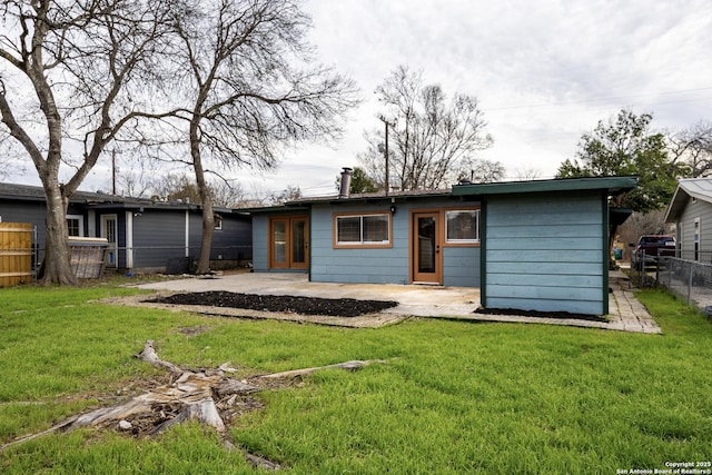 back of property featuring a patio area, a lawn, and fence