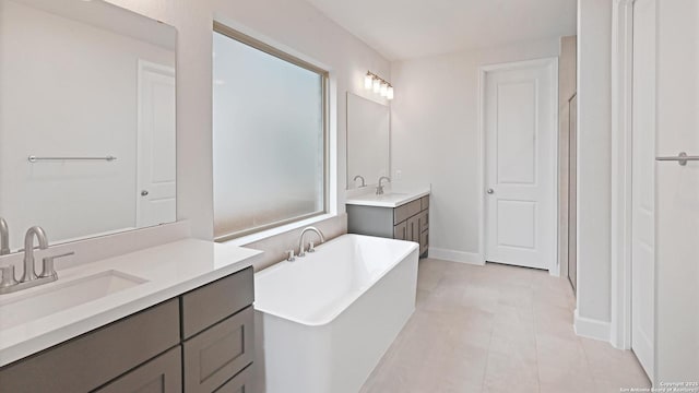 305 Hulda Trl, New Braunfels, TX 78130 - full bathroom featuring a soaking tub, two vanities, tile patterned flooring, and baseboards