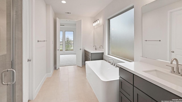 305 Hulda Trl, New Braunfels, TX 78130 - bathroom featuring two vanities, a freestanding tub, a shower stall, baseboards, and tile patterned flooring