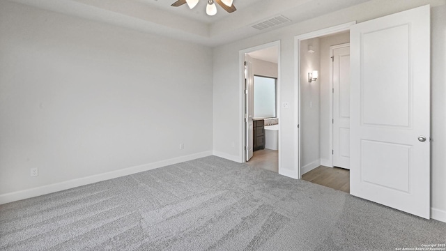 305 Hulda Trl, New Braunfels, TX 78130 - unfurnished bedroom with carpet flooring, baseboards, ensuite bathroom, and a tray ceiling