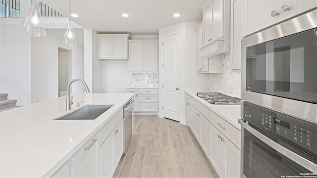 305 Hulda Trl, New Braunfels, TX 78130 - kitchen featuring appliances with stainless steel finishes, a sink, light wood finished floors, light countertops, and recessed lighting