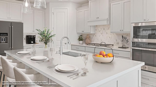 305 Hulda Trl, New Braunfels, TX 78130 - kitchen featuring a sink, stainless steel appliances, a center island with sink, backsplash, and light countertops