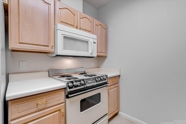 kitchen with electric range oven and light brown cabinetry