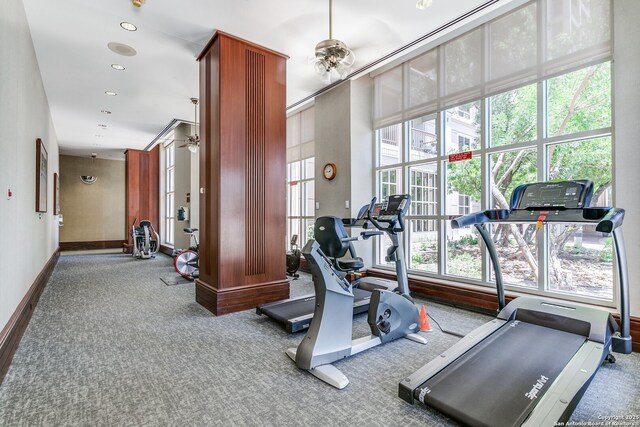 exercise room with ceiling fan and light carpet