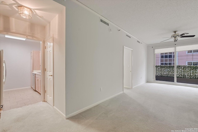 carpeted spare room with ceiling fan and a textured ceiling