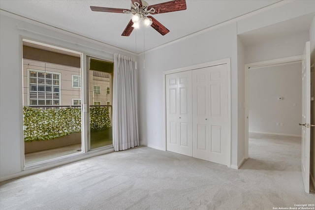 unfurnished bedroom featuring ceiling fan, light colored carpet, a closet, and a textured ceiling