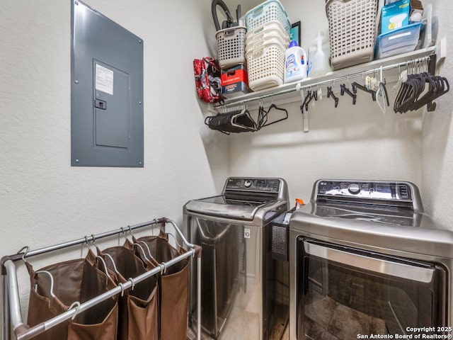 laundry room with electric panel and washing machine and clothes dryer