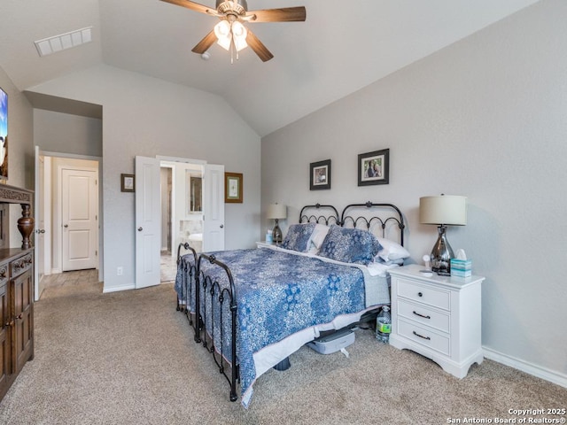 bedroom with vaulted ceiling, connected bathroom, light carpet, and ceiling fan